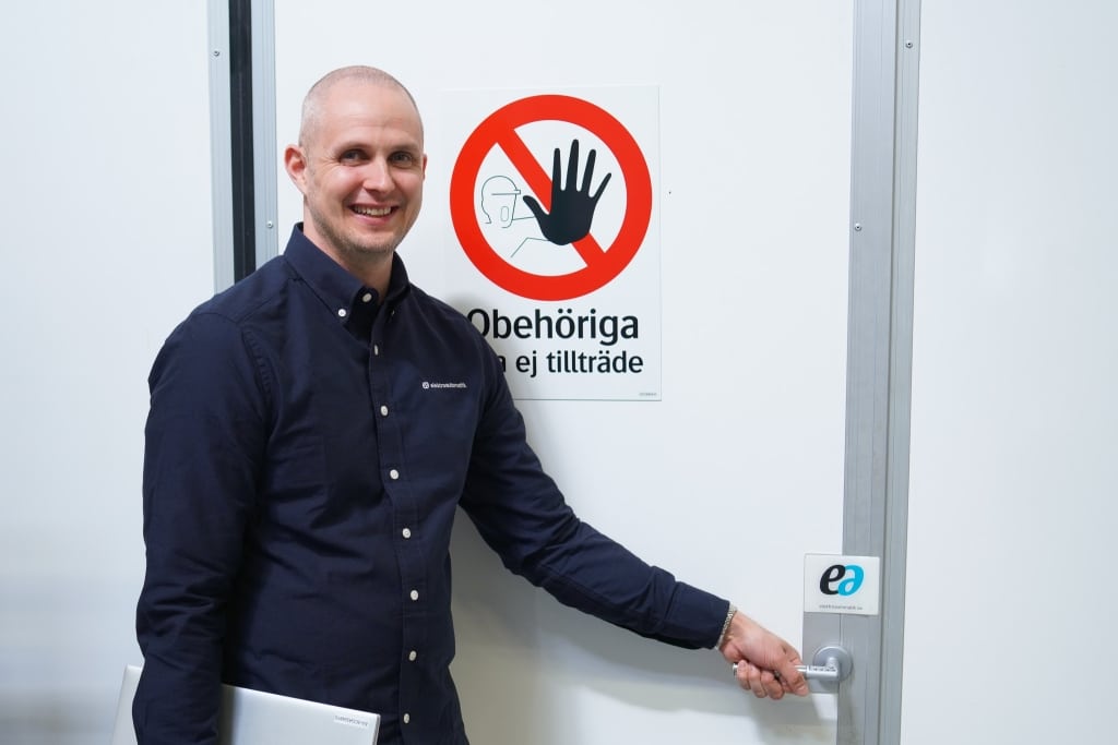 en man står utanför en dörr med texten "obehöriga äga ej tillträde"
